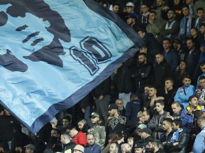 أنصار نابولي يحملون علماً عملاقاً يظهر نجم كرة القدم الأرجنتيني دييغو مارادونا والرقم 10 - AFP