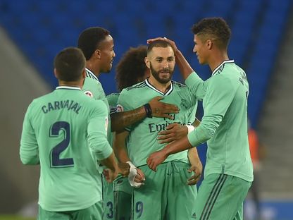 مهاجم ريال مدريد الفرنسي كريم بنزيما يحتفل مع زملائه بتسجيل هدف خلال مواجهة ريال سوسيداد - AFP