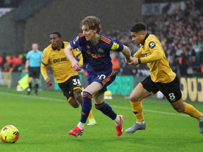 أنطوني غوردون لاعب نيوكاسل يونايتد يمر من جواو جوميز لاعب ولفرهامبتون واندرارز في الدوري الإنجليزي - 18 يناير 2026 - Reuters