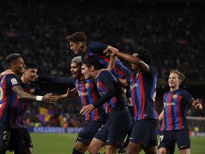 لاعبون من برشلونة يحتفلون بعد تسجيل الهدف الأول ضد ريال بيتيس في الدوري الإسباني - 29 أبريل 2023 - AFP