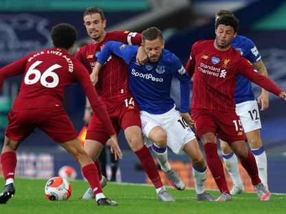 لاعبو ليفربول وإيفرتون يتنافسون على الكرة في مباراتهم الأخيرة بالدوري الإنجليزي - AFP