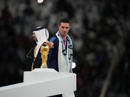 ليونيل سكالوني المدير الفني لمنتخب الأرجنتين يلمس كأس العالم بعد التتويج باللقب في قطر -  18 ديسمبر 2022 - getty