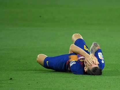 ليونيل ميسي ملقى على الأرض في مباراة أتلتيكو مدريد - AFP