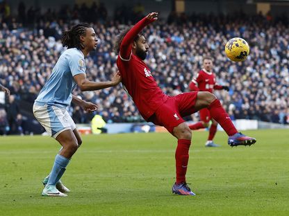 محمد صلاح يحاول ترويض الكرة وخلفه ناثان آكي مدافه مانشستر سيتي - 25 نوفمبر 2023 - reuters