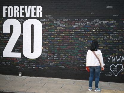 مشجعة لليفربول تقرأ رسائل مكتوبة على جدار تذكاري قرب ملعب "أنفيلد" يتضمّن عبارة "20 للأبد" تكريماً لديوغو جوتا - 9 يوليو 2025 - Reuters