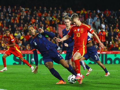 صراع على الكرة بين داني أولمو وفيرجيل فان دايك خلال مباراة بين إسبانيا وهولندا في دوري الأمم الأوروبية - 23 مارس 2025 - REUTERS