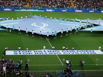 لافتة تطالب بالتوقف عن قتل الأطفال والمدنيين قبل انطلاق السوبر الأوروبي - 13 أغسطس 2025 - Reuters