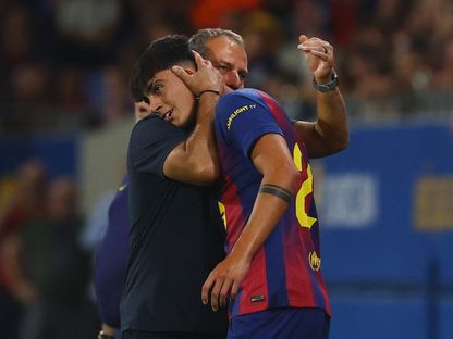 هانزي فليك مدرب برشلونة يحتضن مارك برنال قبل مشاركته أمام فالنسيا في الدوري الإسباني - 14 سبتمبر 2025 - Reuters