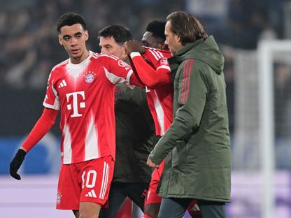 جمال موسيالا لاعب بايرن ميونيخ يواسي زميله ألفونسو ديفيز بعد إصابته أمام أتالانتا في دوري أبطال أوروبا - 10 مارس 2026 - Reuters