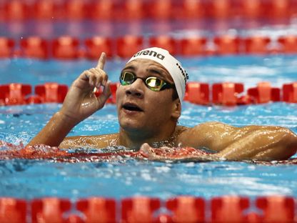 السباح التونسي أحمد الحفناوي يحتفل بعد فوزه بسباق 1500 سباحة حرة في بطولة العالم باليابان - 30 يوليو 2024 - REUTERS