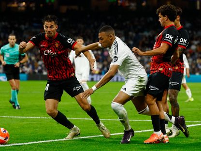 كيليان مبابي مهاجم ريال مدريد يحاول المرور من مدافعي مايوركا في الدوري الإسباني - 14 مايو 2025 - Reuters