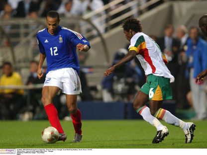 صراع على الكرة بين تييري هنري لاعب منتخب فرنسا وأليو سيسيه لاعب السنغال في افتتاح كأس العالم - 31 مايو 2002 - Reuters