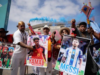 مشجعون في بيرو يحملون صورة ليونيل ميسي ولامين يامال قبل نهائي كأس العالم - 17 يوليو 2026 - Reuters