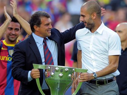 بيب غوارديولا مدرب برشلونة ورئيس النادي جوان لابورتا يحملان كأس الدوري الإسباني بموسم 2009-2010 - 25 أغسطس 2010 - Reuters