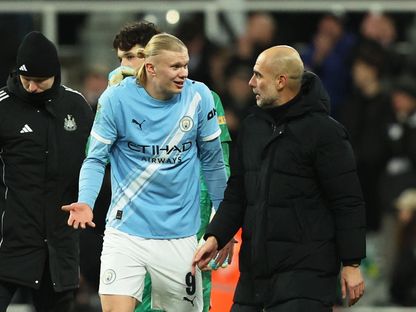 بيب غوارديولا مدرب مانشستر سيتي يتحدث مع إيرلينغ هالاند بعد الفوز على نيوكاسل في ذهاب نصف نهائي كأس الرابطة - 13 يناير 2026 - Reuters