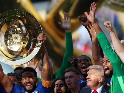 لاعب تشيلسي ريس جيمس يرفع كأس العالم للأندية في الاحتفال مع زملائه في الفريق بوجود ينظر الرئيس الأمريكي دونالد ترمب - 13 يوليو 2025 - Reuters