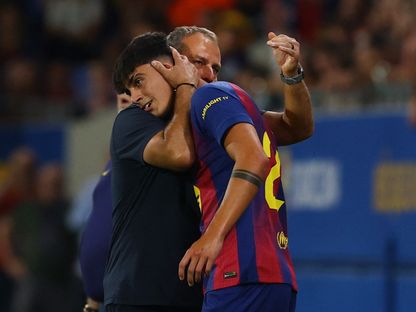 هانزي فليك مدرب برشلونة يحتضن مارك بيرنال قبل مشاركته أمام فالنسيا في الدوري الإسباني - 14 سبتمبر 2025 - Reuters