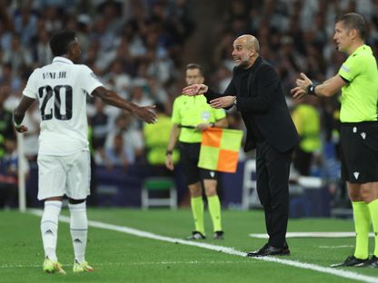 بيب غوارديولا وفينيسيوس جونيور خلال مباراة بين مانشستر سيتي وريال مدريد في دوري أبطال أوروبا - 9 مايو 2023 - REUTERS