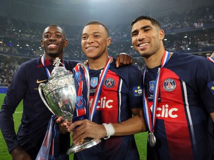كيليان مبابي وأشرف حكيمي وعثمان ديمبيلي يحتفلون بلقب كأس فرنسا بعد فوز باريس سان جيرمان على أولمبيك ليون في النهائي - 25 مايو 2024 - REUTERS