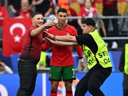 أحد المشجعين يقتحم الملعب ويحاول التقاط صورة مع كريستيانو رونالدو خلال مباراة البرتغال وتركيا في بطولة أوروبا - 23 يونيو 2024 - Reuters