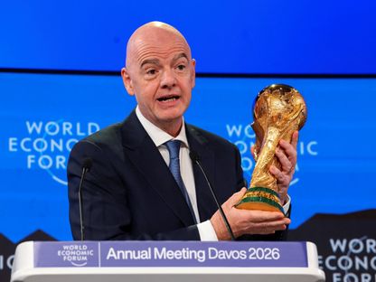 رئيس الاتحاد الدولي لكرة القدم جياني إنفانتينو يحمل كأس العالم خلال الاجتماع السنوي الـ56 للمنتدى الاقتصادي العالمي في دافوس - 22 يناير 2026 - Reuters