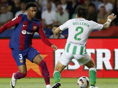 أليخاندرو بالدي لاعب برشلونة يراوغ هيكتور بيليرين لاعب ريال بيتيس خلال مواجهة الفريقين  - REUTERS