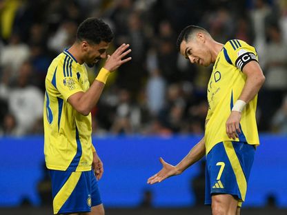 كريستيانو رونالدو نجم النصر يحتفل مع زميله علي لاجامي بتسجيل هدف في مرمى ضمك بالدوري السعودي - 29 فبراير 2024 - Reuters