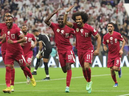 أكرم عفيف يحتفل مع لاعبين قطريين بتسجيله هدفاً في مرمى الأردن بنهائي كأس آسيا - 10 فبراير 2024 - AFP