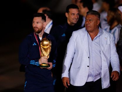 كلاوديو تابيا رئيس الاتحاد الأرجنتيني لكرة القدم وليونيل ميسي مع كأس العالم خلال وصول منتخب الأرجنتين إلى مطار إيزيزا الدولي - 20 ديسمبر 2022 - Reuters