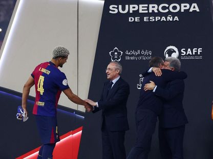 فلورنتينو بيريز رئيس ريال مدريد يصافح رونالد أراوخو مدافع برشلونة وبجواره جوان لابورتا رئيس برشلونة يعانق المدرب هانزي فليك بعد الفوز بالسوبر الإسباني في جدة - 13 يناير 2025 - Reuters