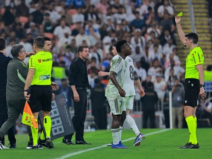 الحكم ماتيو بوسكيتس فيرير يُنذر فينيسيوس وبدا دييغو سيميوني خلال مباراة ريال مدريد وأتلتيكو مدريد في نصف نهائي كأس السوبر الإسباني - 8 يناير 2026 - REUTERS