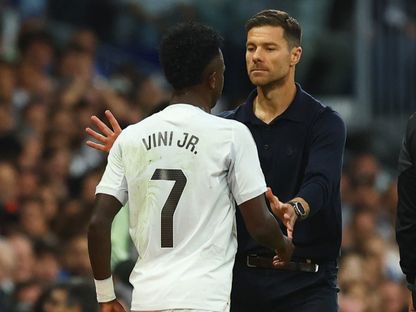 مدرب ريال مدريد تشابي ألونسو مع فينيسيوس جونيور خلال مباراة بين ريال مدريد وبرشلونة - 26 أكتوبر 2025 - REUTERS