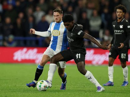 جايدن هيسكي لاعب مانشستر سيتي في صراع على الكرة مع بن ويلز لاعب هدرسفيلد تاون في كأس رابطة الأندية الإنجليزية - 24 سبتمبر 2025 - Reuters