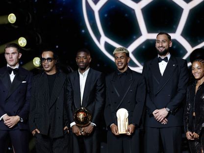 من اليمين فيكي لوبيز وجيانلويجي دوناروما ولامين يامال وعثمان ديمبيلي مع جائزة الكرة الذهبية ورونالدينيو وفيكتور غيوكيريس في صورة تذكارية خلال حفل الكرة الذهبية - 22 سبتمبر 2025 - Reuters