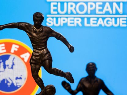 تمثال معدني للاعب كرة قدم وخلفه شعاري السوبر ليغ والاتحاد الأوروبي لكرة لقدم - REUTERS