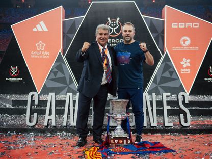 رئيس برشلونة جوان لابورتا والمدرب هانزي فليك مع كأس السوبر الإسباني بعد إحراز اللقب أمام ريال مدريد في جدة - 11 يناير 2026 - @FCBarcelona