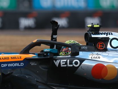 لاندو نوريس يرفع يده لتحية الجماهير بعد الفوز بسباق بريطانيا لفورمولا 1 - 6 يوليو 2025 - X/@mclarenf1
