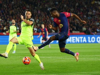 لاعب برشلونة أنسو فاتي مع مارتن فالينت لاعب نادي مايوركا في الدوري الإسباني - 22 أبريل 2025 - Reuters