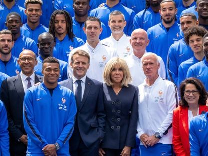 الرئيس الفرنسي إيمانويل ماكرون وزوجته في صورة تذكارية مع أعضاء المنتخب خلال زيارته لمعسكر الفريق قبل كأس العالم - 2 يونيو 2026 - @EmmanuelMacron/x
