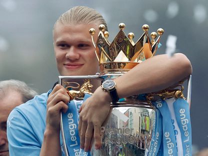 إيرلينغ هالاند مع كأس الدوري الإنجليزي الممتاز على حافلة خلال موكب النصر لمانشستر سيتي - 26 مايو 2024 - Reuters