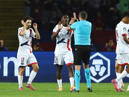 نونو مينديز وفيتينيا مع الحكم مايكل أوليفر خلال مباراة بين برشلونة وباريس سان جيرمان في دوري أبطال أوروبا - 1 أكتوبر 2025 - REUTERS