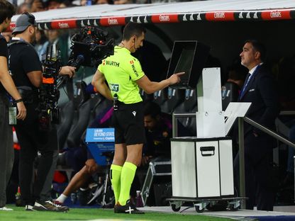الحكم سيزار سوتو غرادو يراجع شاشة تقنية الفيديو المساعد (VAR) لمراجعة قرار منح ريال مدريد ركلة جزاء أمام برشلونة - 26 أكتوبر 2025 - Reuters