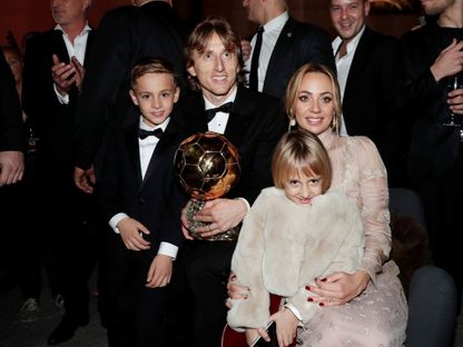 الكرواتي لوكا مودريتش نجم ريال مدريد يحمل الكرة الذهبية لعام 2018 رفقة عائلته - 3 ديسمبر 2018 - REUTERS