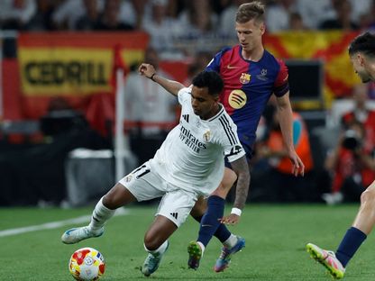 لاعب ريال مدريد رودريغو وداني أولمو لاعب برشلونة خلال نهائي كأس ملك إسبانيا - 26 أبريل 2025 - Reuters