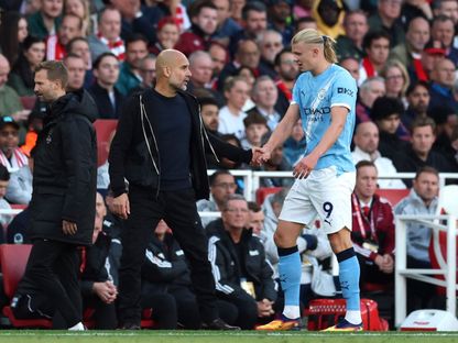 بيب غوارديولا مدرب مانشستر سيتي يتحدث مع لاعبه إيرلينغ هالاند بعد استبداله بمواجهة أرسنال في الدوري الإنجليزي الممتاز - 21 سبتمبر 2025 - Reuters