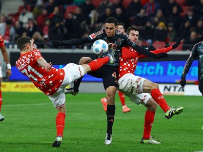 نجم بايرن ميونيخ جمال موسيالا محاصر بين لاعبين من ماينتس في مباراة بالبوندسليغا 14-12-2024 - Reuters