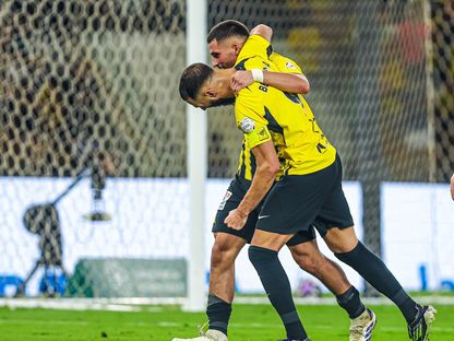 حسام عوار يحتفل مع زميله كريم بنزيما بهدف الاتحاد الرابع في مرمى الرائد بدوري روشن السعودي - 16 يناير 2025 - X/@ittihad