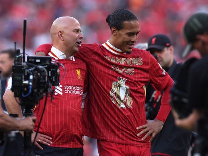 فيرجيل فان دايك مدافع ليفربول يحتفل مع المدرب آرني سلوت بالتتويج بلقب الدوري الإنجليزي الممتاز - 29 أبريل 2025 - Reuters