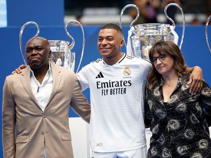 كيليان مبابي مع والديه ويلفريد مبابي وفايزة العماري خلال تقديمه لاعباً في ريال مدريد على ملعب "سانتياغو برنابيو" - 16 يوليو 2024 - Reuters