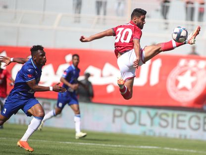 ياسين الشماخي لاعب النجم الساحلي (بالقميص الأحمر) يحاول السيطرة على الكرة وسط متابعة من عمر فال لاعب الاتحاد المنستيري في الدوري التونسي - 4 مايو 2024 - AWP